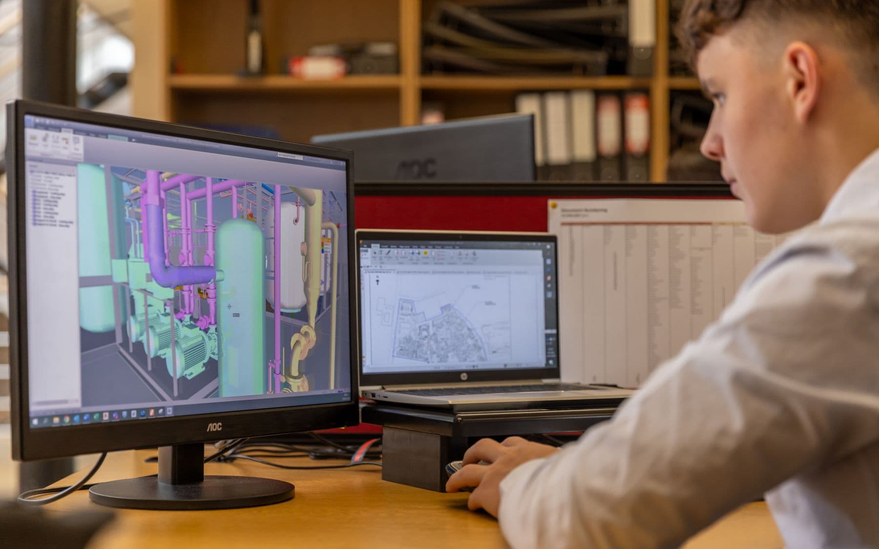 Kỹ sư làm việc với bản vẽ CAD trên máy trạm